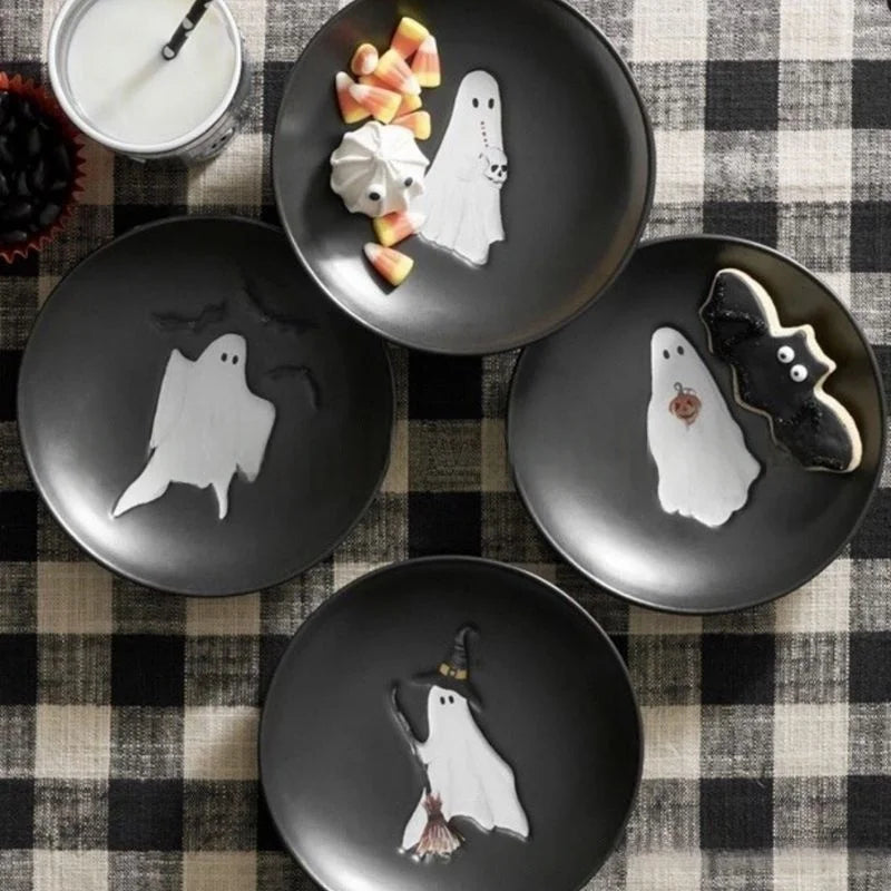 Black plates with ghost designs on a checkered tablecloth