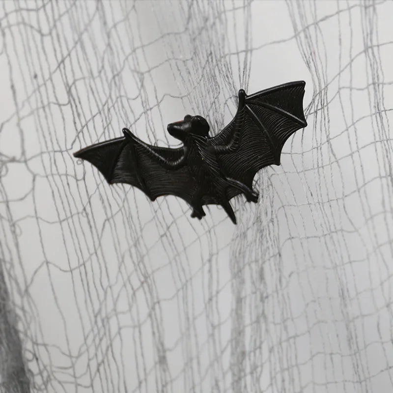 Black bat figurine on a textured white background